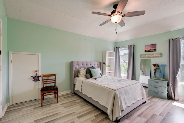 bedroom with light wood-type flooring, a textured ceiling, and ceiling fan