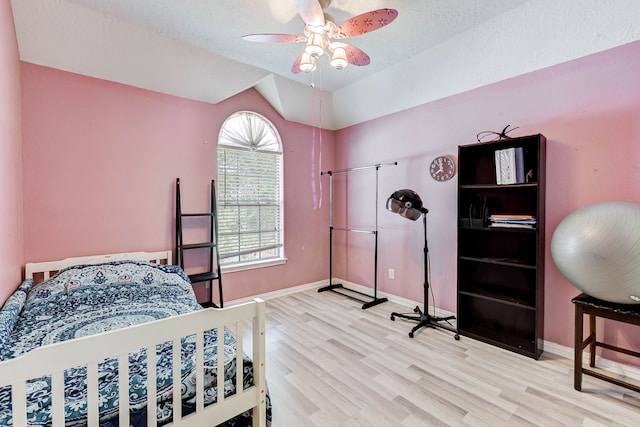 bedroom with ceiling fan, a textured ceiling, and light wood-type flooring