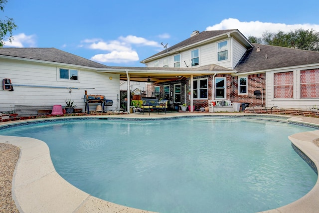 view of swimming pool featuring ceiling fan and a patio area