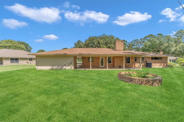 back of house featuring central AC unit, a lawn, and a patio area