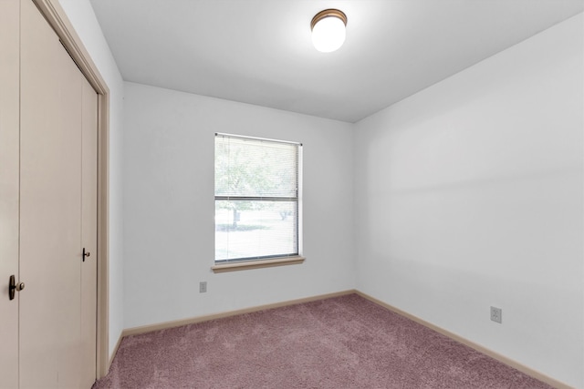 unfurnished bedroom featuring light colored carpet and a closet