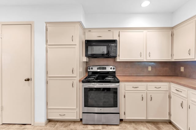 kitchen with stainless steel range with electric stovetop, cream cabinets, light tile patterned floors, and tasteful backsplash