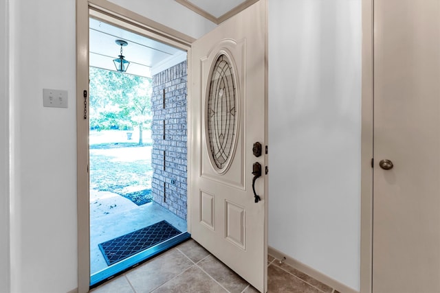 foyer entrance featuring ornamental molding and light tile patterned flooring