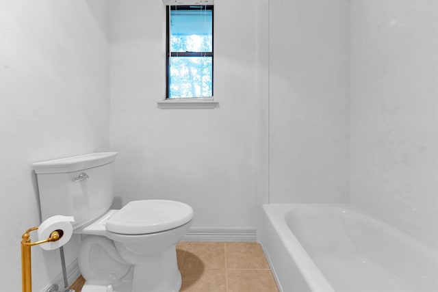 bathroom featuring a bathing tub, tile patterned flooring, and toilet