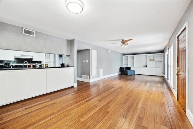 unfurnished living room featuring ceiling fan and light hardwood / wood-style floors