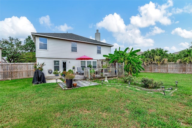 back of house featuring a wooden deck and a yard