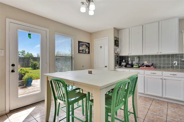 kitchen with backsplash, white cabinets, and light tile patterned floors