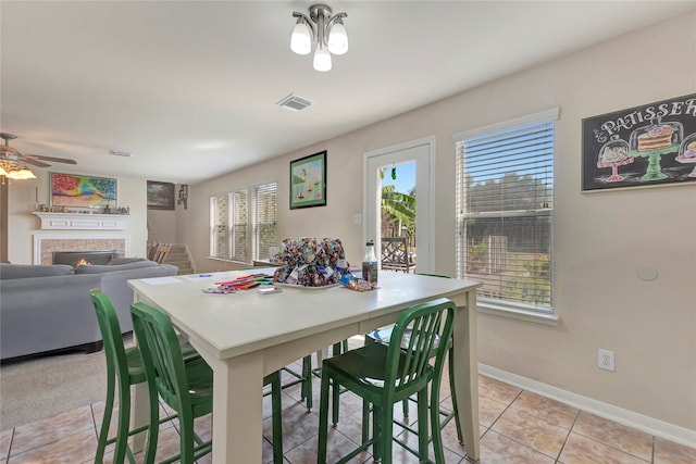 tiled dining space with ceiling fan