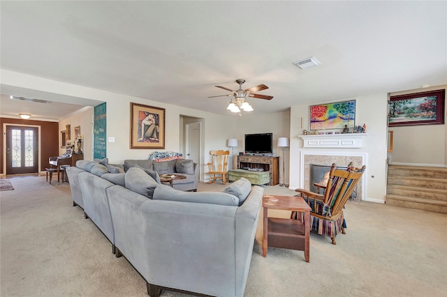 carpeted living room featuring ceiling fan, ornamental molding, and a fireplace