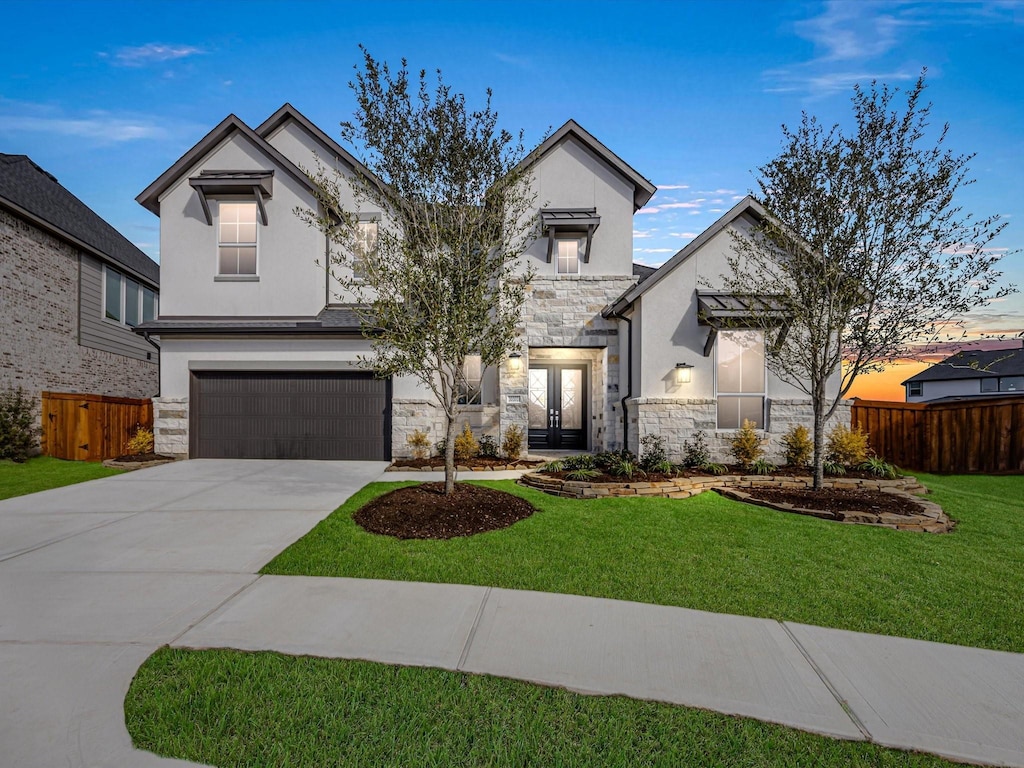 view of front of home featuring a lawn, french doors, and a garage