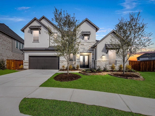 view of front of home featuring a lawn, french doors, and a garage