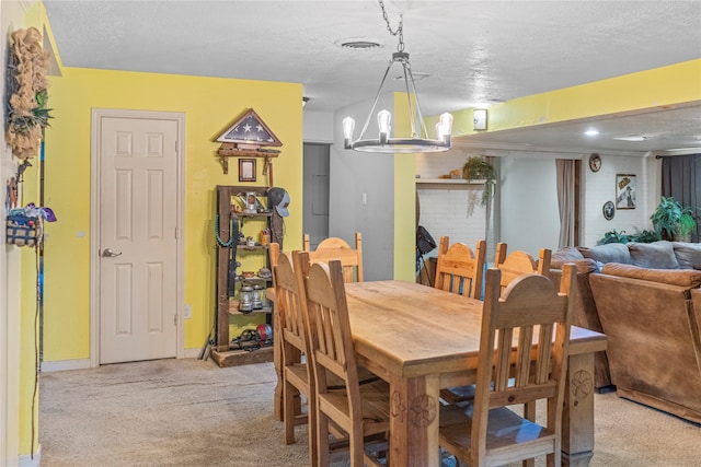 dining area featuring a textured ceiling, a fireplace, light carpet, and an inviting chandelier