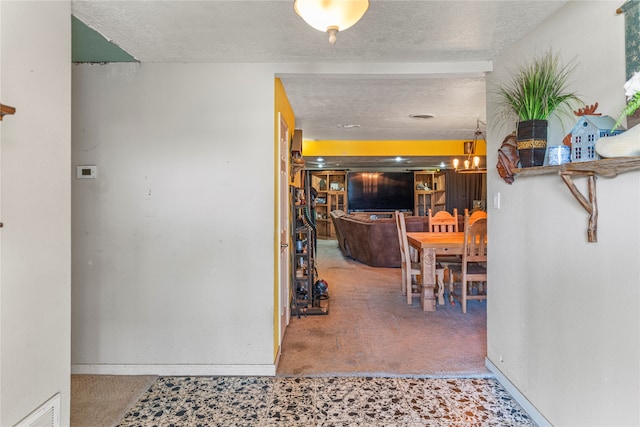 hallway featuring a textured ceiling and carpet floors