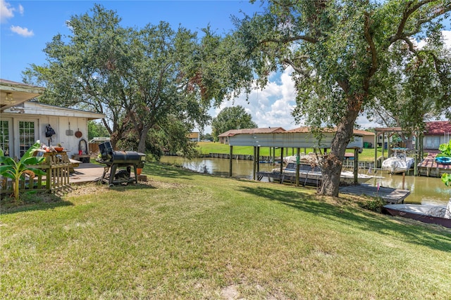 view of yard featuring a water view and a boat dock