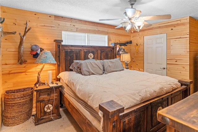 carpeted bedroom featuring wood walls, ceiling fan, and a textured ceiling