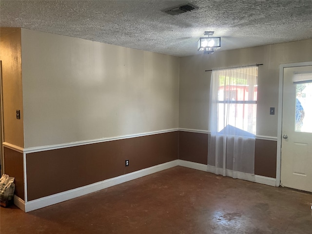 entryway featuring a textured ceiling, concrete floors, and a healthy amount of sunlight