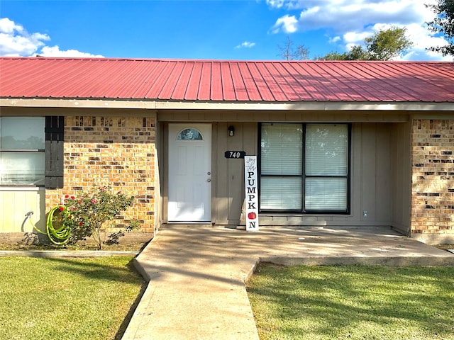 view of exterior entry with a yard