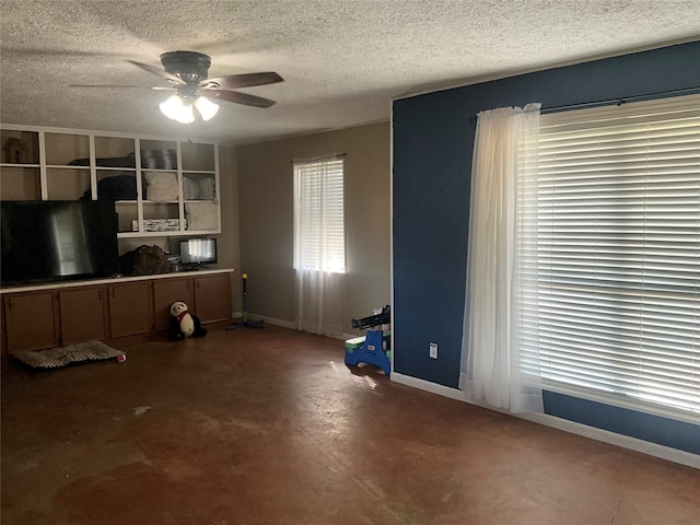 interior space featuring a textured ceiling, concrete floors, and ceiling fan