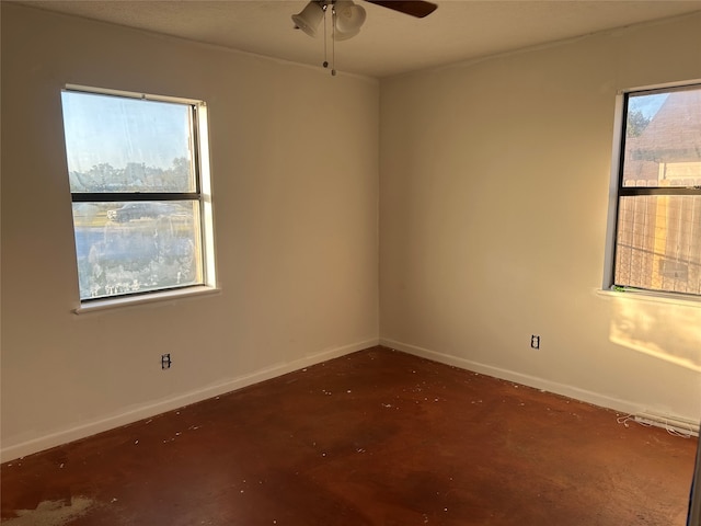 spare room featuring ceiling fan and plenty of natural light