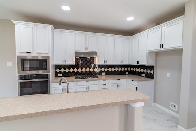 kitchen featuring white cabinets, appliances with stainless steel finishes, sink, and tasteful backsplash