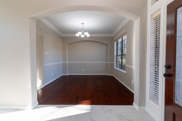 unfurnished dining area with ornamental molding, a chandelier, and light hardwood / wood-style floors