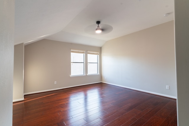 empty room featuring ceiling fan, vaulted ceiling, and dark wood-type flooring