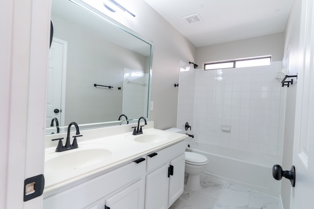 full bathroom featuring tiled shower / bath, vanity, and toilet