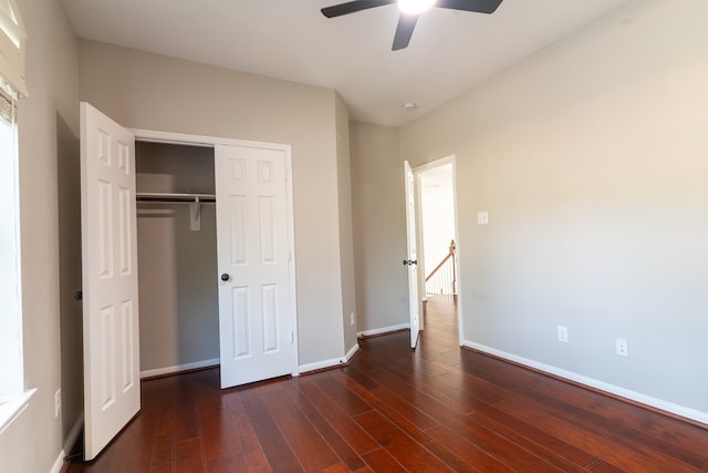 unfurnished bedroom with ceiling fan, a closet, and dark hardwood / wood-style flooring