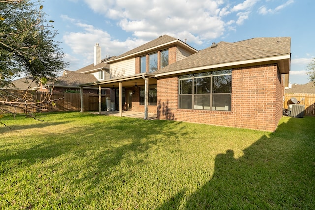 back of property with a lawn and a patio area