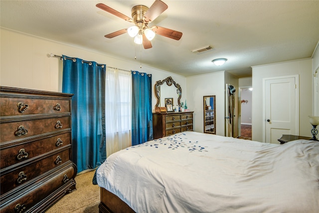 carpeted bedroom with ceiling fan and a textured ceiling