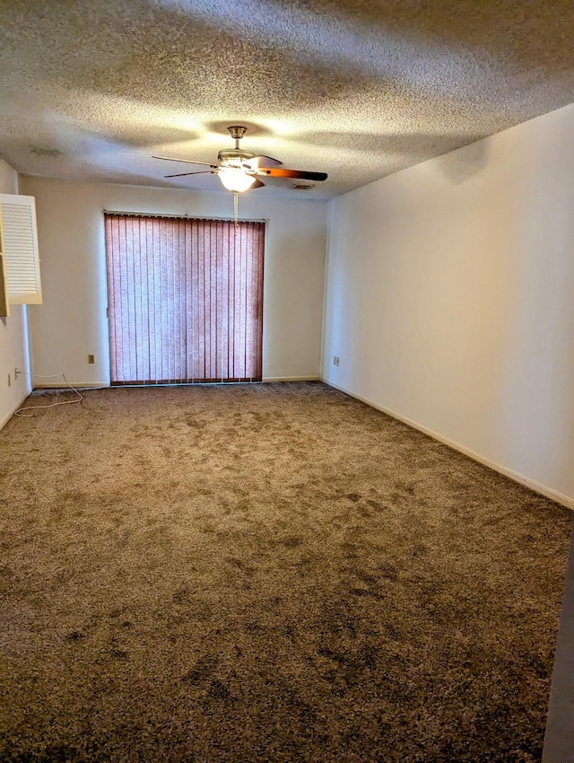 empty room featuring ceiling fan, a textured ceiling, and carpet