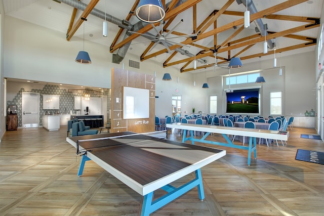 playroom with high vaulted ceiling and light parquet floors