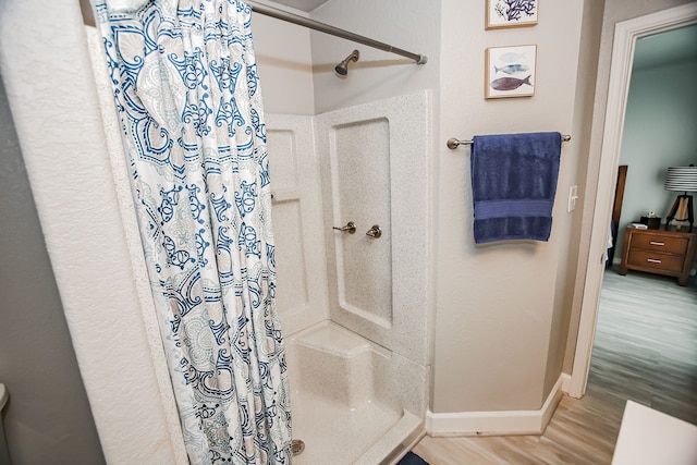 bathroom with hardwood / wood-style floors and curtained shower