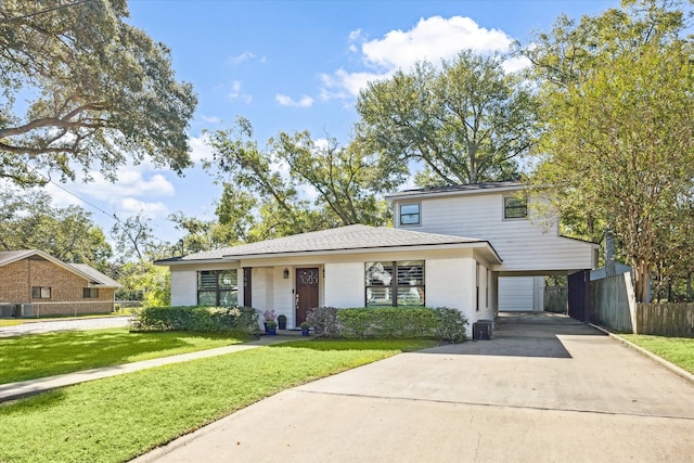 view of front of home with a front lawn, central AC unit, and a garage