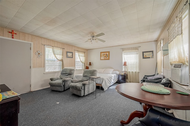 bedroom with carpet floors, wooden walls, and ceiling fan