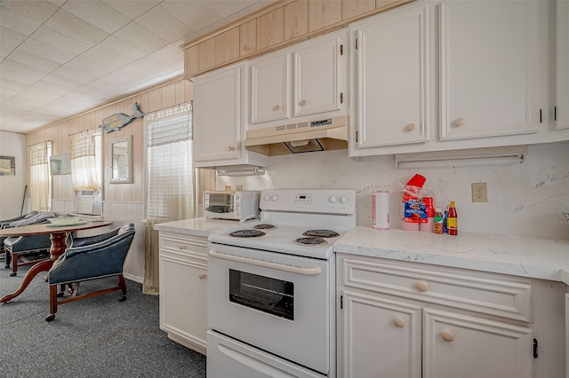 kitchen featuring electric stove, wood walls, white cabinetry, and ventilation hood