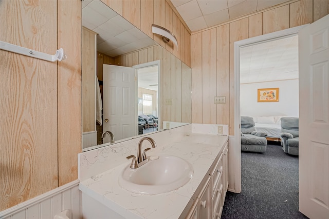 bathroom featuring vanity and wood walls