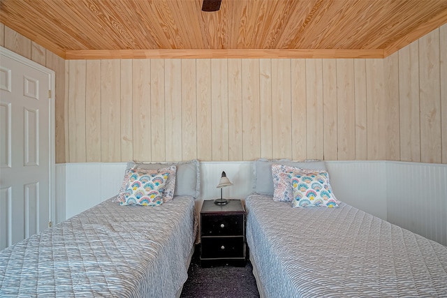 bedroom featuring wood ceiling, wooden walls, and ceiling fan