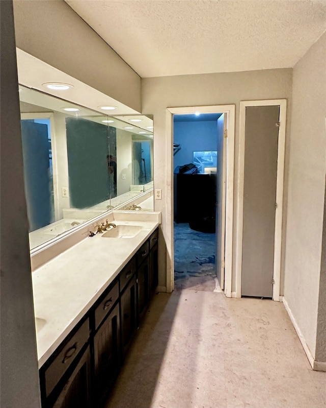 bathroom featuring a textured ceiling and vanity