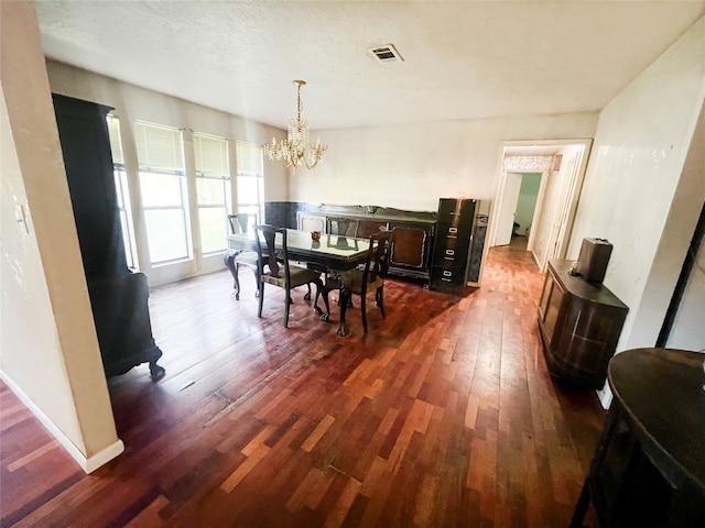 dining room featuring an inviting chandelier, dark hardwood / wood-style floors, and a textured ceiling