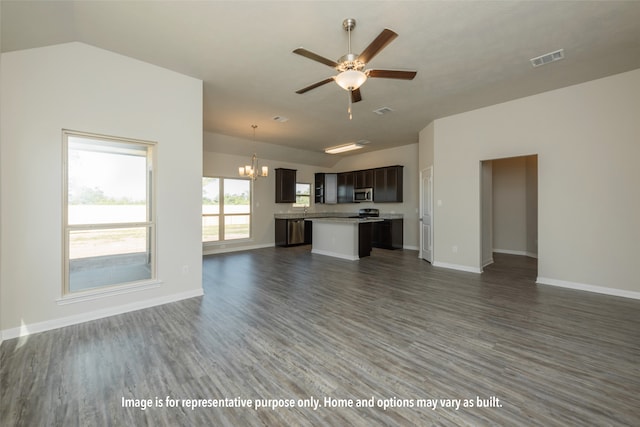 unfurnished living room featuring ceiling fan with notable chandelier, vaulted ceiling, and dark wood-type flooring