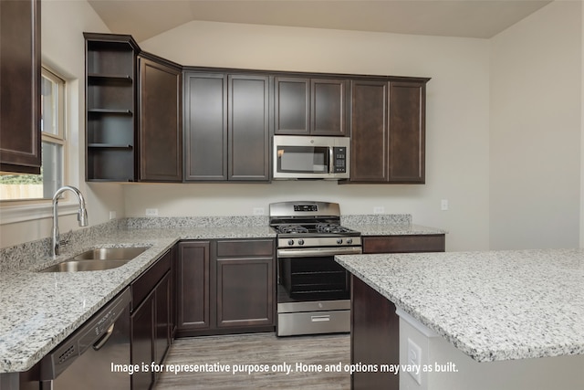 kitchen featuring sink, dark brown cabinets, light hardwood / wood-style flooring, stainless steel appliances, and vaulted ceiling