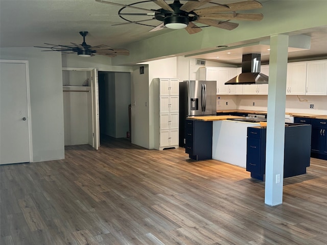 kitchen featuring blue cabinets, white cabinetry, hardwood / wood-style floors, and range hood