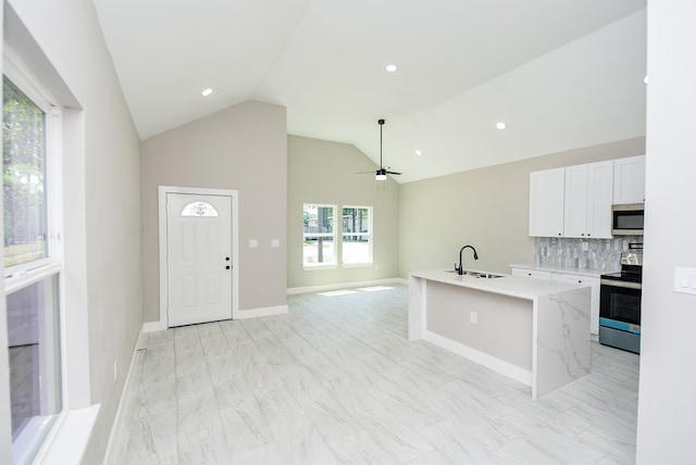 kitchen featuring ceiling fan, white cabinets, an island with sink, sink, and appliances with stainless steel finishes