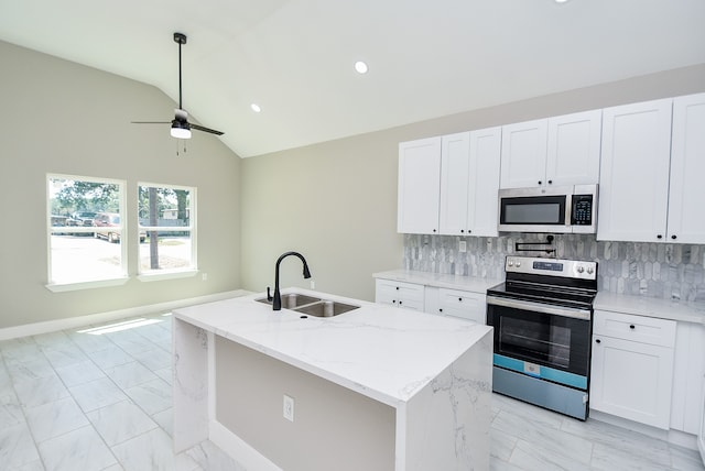 kitchen with stainless steel appliances, vaulted ceiling, a kitchen island with sink, and sink