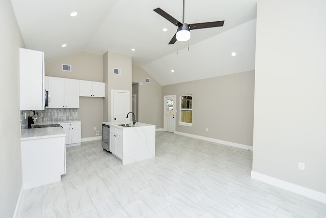 kitchen featuring black stove, light stone counters, white cabinets, a kitchen island with sink, and sink