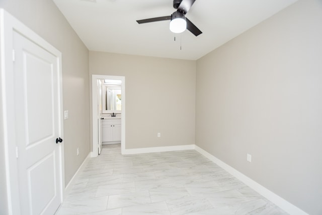 unfurnished bedroom featuring connected bathroom, sink, and ceiling fan