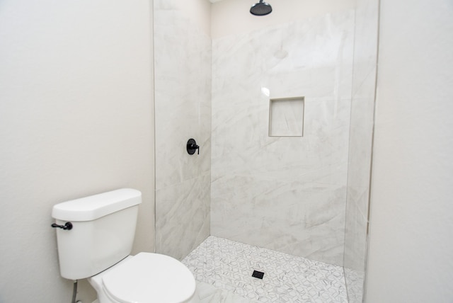 bathroom featuring toilet and tiled shower