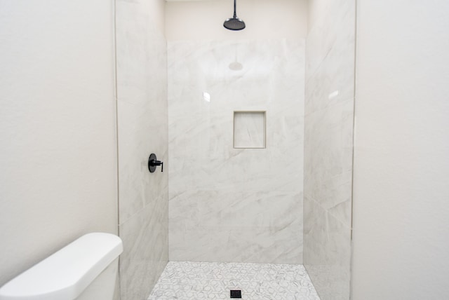 bathroom with toilet and tiled shower