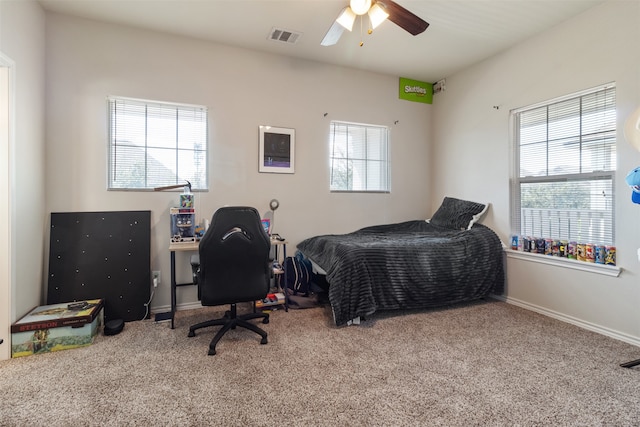 carpeted bedroom with ceiling fan and multiple windows